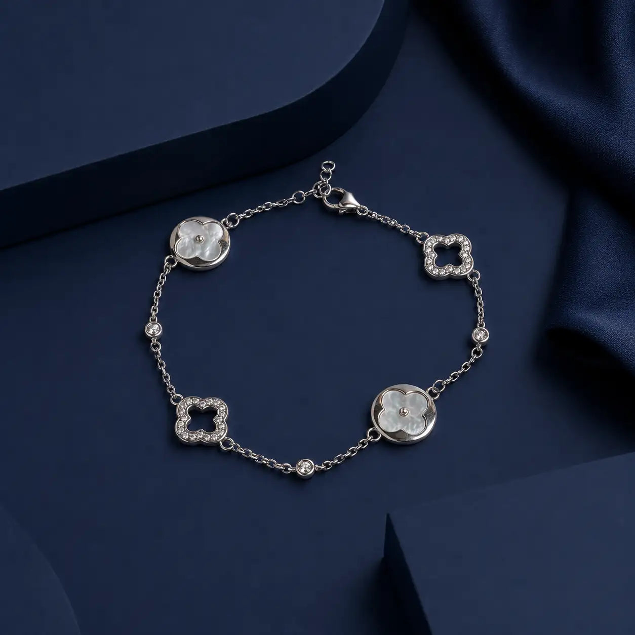 Silver four-leaf clover bracelet featuring mother-of-pearl inlays and diamond accents.